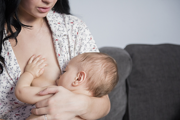 Caucasian mother breastfeeding baby son on sofa Photograph by JGI/Jamie Grill