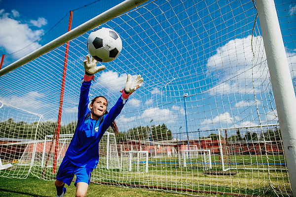 Teenager goalkeeper playing soccer and defending penalty kicks Photograph by Drazen_