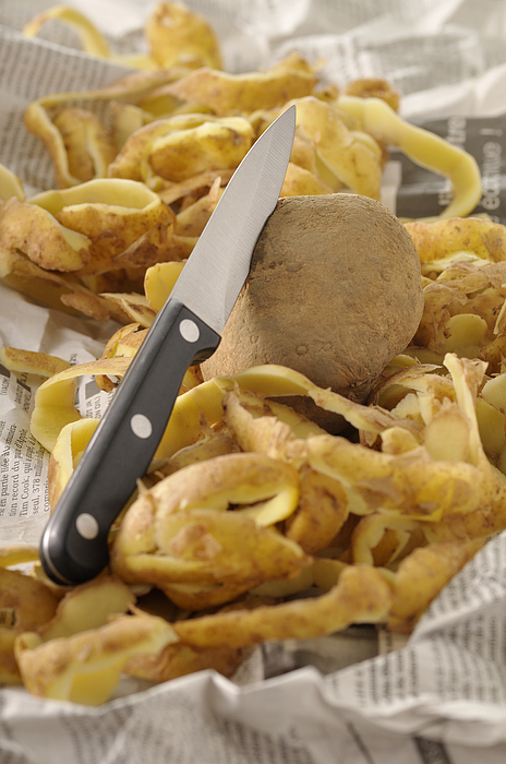 A potato, knife and peelings Photograph by Riou