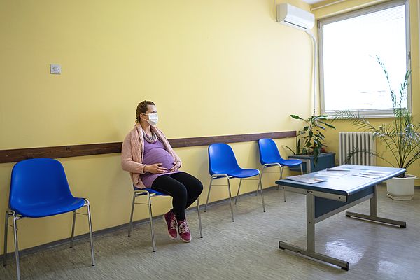 A young pregnant woman with a protective mask in the waiting room Photograph by Viktorcvetkovic