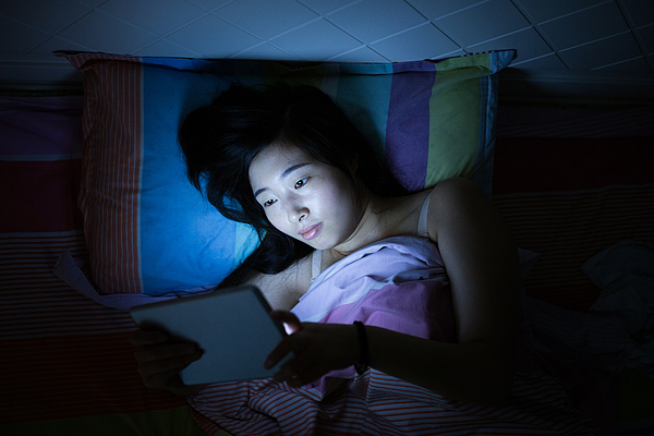 Asian girls reading tablet in bed Photograph by Linghe Zhao