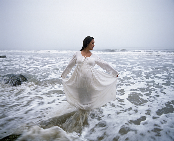 Pregnant woman wearing white dress, standing in sea Photograph by Macduff Everton