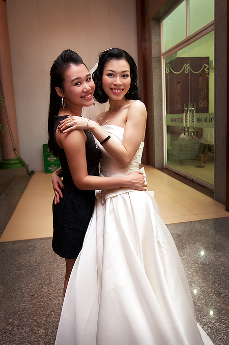 Two Asian girls at a wedding Photograph by Image by Adam Young