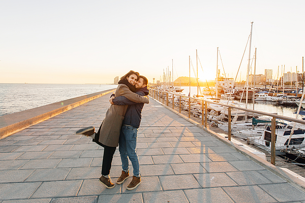 Young happy couple hugging each other at the pier in Barcelona, Spain Photograph by Alexander Spatari