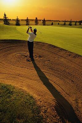 Sports Royalty-Free and Rights-Managed Images - Golfer Taking A Swing From A Golf Bunker by Darren Greenwood