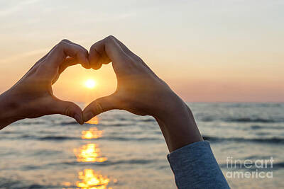 Beach Photos - Heart shaped hands framing ocean sunset by Elena Elisseeva