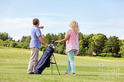 Sports Photos - Active senior couple playing golf on a course. by Michal Bednarek