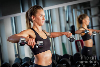 Athletes Photos - Attractive woman weightlifting at the gym. by Michal Bednarek