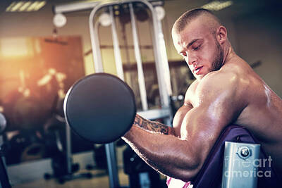 Athletes Royalty Free Images - Muscular man working out at a gym. Royalty-Free Image by Michal Bednarek