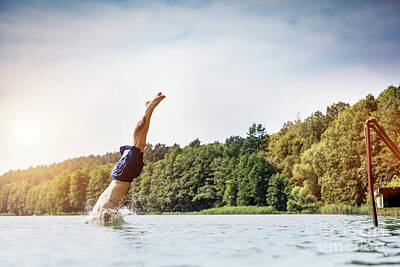 Athletes Photos - Young man diving into a lake. by Michal Bednarek