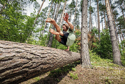 Athletes Photos - Young man jumping over a tree trunk in the forest. by Michal Bednarek