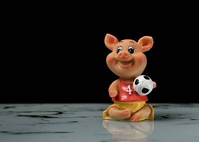Football Rights Managed Images - Figurine of a small piggy with a football in its hand Royalty-Free Image by Stefan Rotter