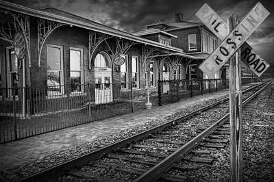 Randall Nyhof Royalty Free Images - Old Train Station with Crossing Sign in Black and White Royalty-Free Image by Randall Nyhof