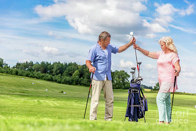 Sports Photos - Senior couple choosing equipment for a golf game. by Michal Bednarek