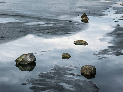 Abstract Skyline Photos - Stones lying on the melting ice of a frozen river by Stefan Rotter