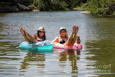 Cowboy - Two attractive females lounge on inner tube floats at a swimming hole on the Bull Creek Greenbelt by Dan Herron