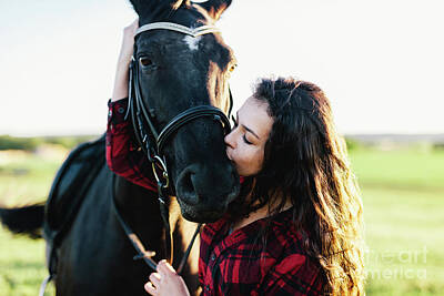 Animals Photos - Young girl kissing bay horses muzzle. by Michal Bednarek