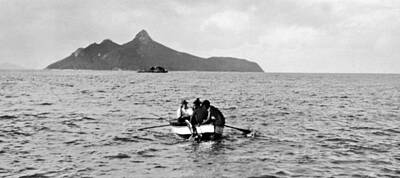Reptiles Royalty-Free and Rights-Managed Images - Messsr Shepherd and Lingard bringing aboard a captured Turtle Lion Island in distance  c 1931 by Celestial Images