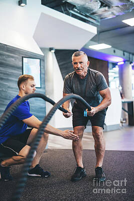 Athletes Photos - Senior man exercising with ropes at the gym. by Michal Bednarek