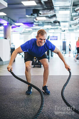 Athletes Photos - Young man exercising with ropes at the gym. by Michal Bednarek