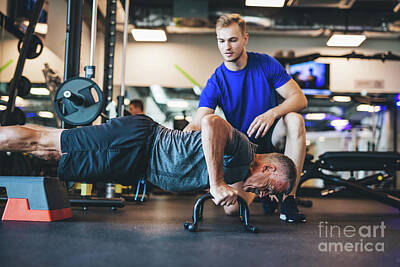 Athletes Photos - Young man helping senior man in a workout. by Michal Bednarek