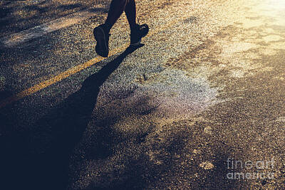 Athletes Royalty Free Images - A lonely runner trains on wet asphalt at sunset, copy space. Royalty-Free Image by Joaquin Corbalan