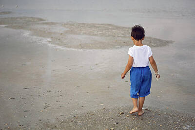 Home For The Holidays - tanned child boy in blue shorts and a white T-shirt walks barefoot the lake in summer by Elena Saulich