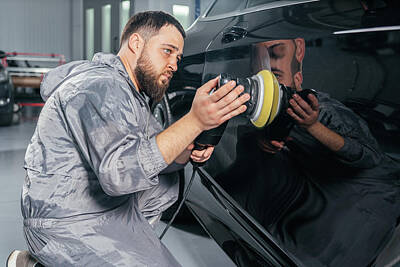 Up Up And Away - Worker polishing car with special grinder and wax from scratches at the car service station. Professional car detailing and maintenance concept by Maria Kray