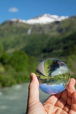 Abstract Animalia - Glass sphere held in hand, river and mountains on a sunny day by Stefan Rotter