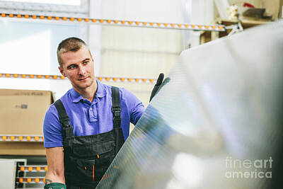 Portraits Photos - Glazier worker portrait with glass in workshop. Industry by Michal Bednarek