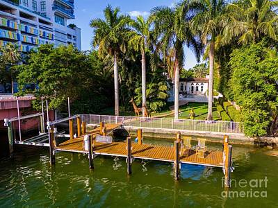 Cargo Boats Rights Managed Images - Low angle aerial view of luxury Miami waterfront mansion with palms and boat dock Royalty-Free Image by Felix Mizioznikov