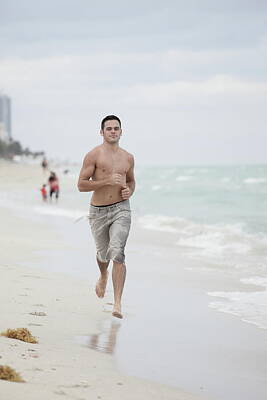 Beach Photos - Man running on the beach by the shore by Felix Mizioznikov