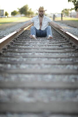 Creative Charisma - Man sitting between railroad tracks by Felix Mizioznikov