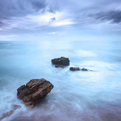 Nailia Schwarz Food Photography - Rocks in a ocean waves under cloudy sky. Bad weather. by Stefano Orazzini