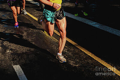 Athletes Photos - Running athletes have powerful quadriceps and calf muscles for running on asphalt. by Joaquin Corbalan