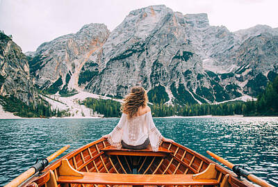 Womens Empowerment Rights Managed Images - Silhouette back woman long hair flying fluttering wind, turned away face sitting in wooden boat. Tourist white blouse long sleeves enjoy nature Italian mountains alpine lake. river waves green forest Royalty-Free Image by Julien